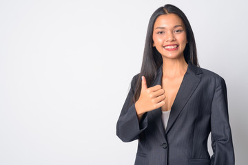 Portrait of happy young beautiful Asian businesswoman giving thumbs up