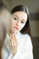 Fototapeta na wymiar Female beauty, beautiful teen girl applying make up in bathroom at home.