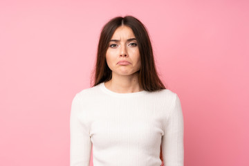 Fototapeta premium Young woman over isolated pink background sad