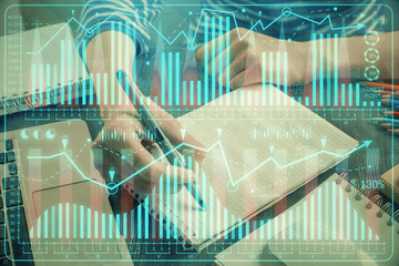 Financial chart drawn over hands taking notes background. Concept of research. Double exposure