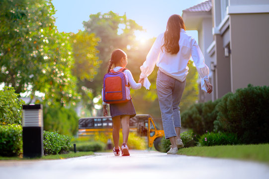 mother on the way sending daughter girl to school bus in the first day of study learning