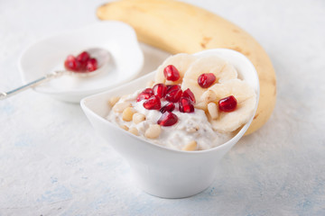 Oatmeal and yogurt smoothie with pomegranate, banana and pine nuts