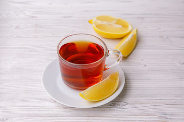 a cup of tea with lemon on a white wooden table