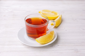 a cup of tea with lemon on a white wooden table