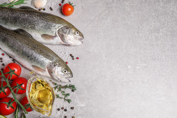 Flat lay composition with cutthroat fish on light grey table, space for text
