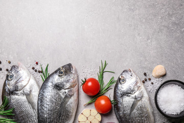 Flat lay composition with dorada fish on light grey table, space for text