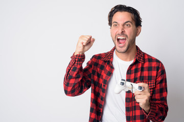 Portrait of happy Hispanic hipster man playing games and winning