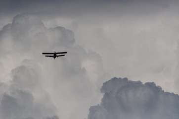 Fototapeta na wymiar BIPLANE IN THE SKY - Flight of a classic airplane among the clouds