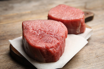 Fresh raw beef cut on wooden table, closeup