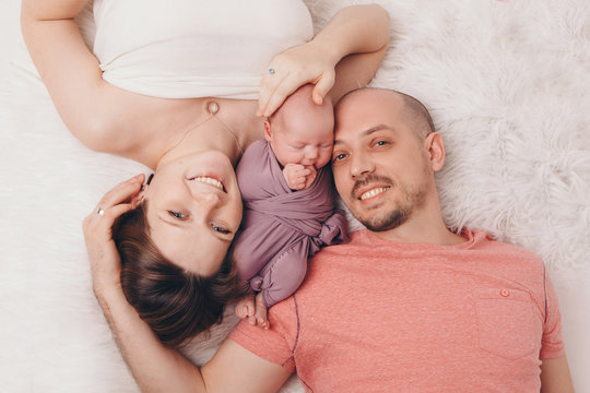 Family Photo On A White Background: Parents Spend Time With Their Children. Mom And Dad Hug The Baby. The Concept Of Childhood, Fatherhood, Motherhood, IVF