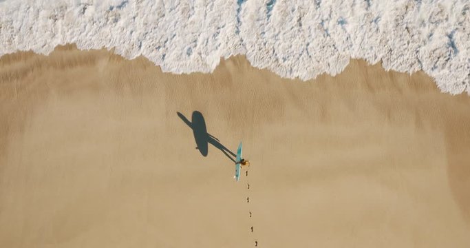 Aerial view of a woman going surfing