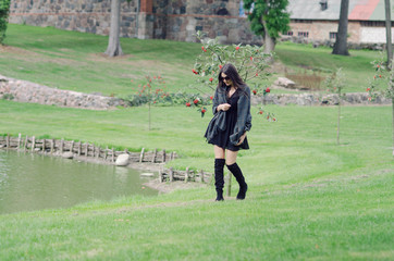 Girl with hair developing in the wind walks on green grass