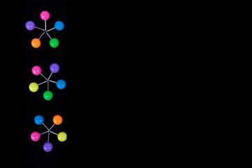 Multicolored push button office laid out in the form of flowers on a black background.Copy space.Decoration concept and place for notes.