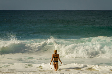 Girl in a bikini walking to the ocean