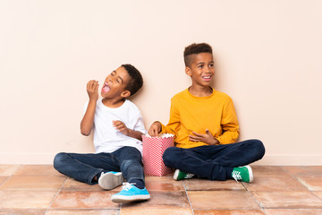 Happy African American brothers  holding popcorns