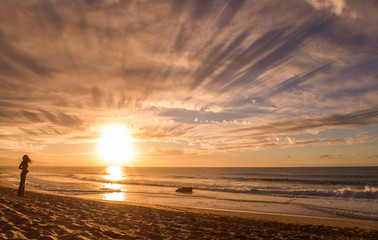 girl watching sunset at the beach in hawaii