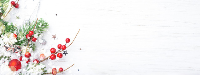 Christmas banner with fir branches, berries and snow. New Year background with copy space.