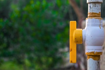 closeup of a water pipe with on off lever to control the water supply with dark background 