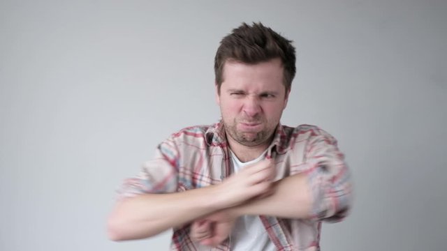 Man scratching the itch with hand. Problem with skin after mosquito bite.