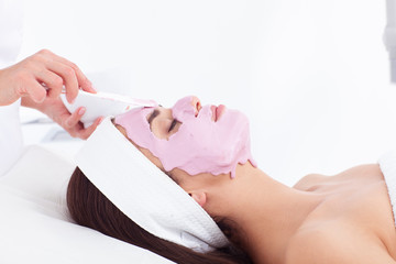 Naklejka premium Cosmetologist is applying a mask on a woman face.