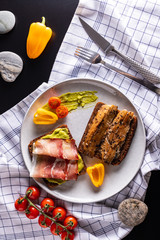 Homemade smoked herring and schwarzwald ham sandwiches with rye bread on light grey plate, top view 