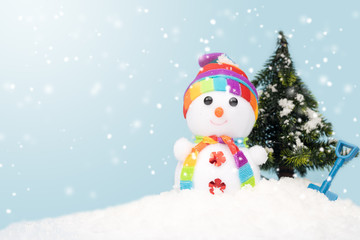 Cute snowman on fake snow with copy space on blue background.