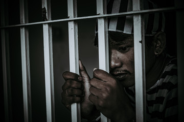 Portrait of Asian men desperate to catch the iron prison,prisoner concept,thailand people,Hope to...