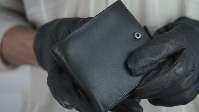 Thief of wallet. Thief in gloves with a stolen wallet.