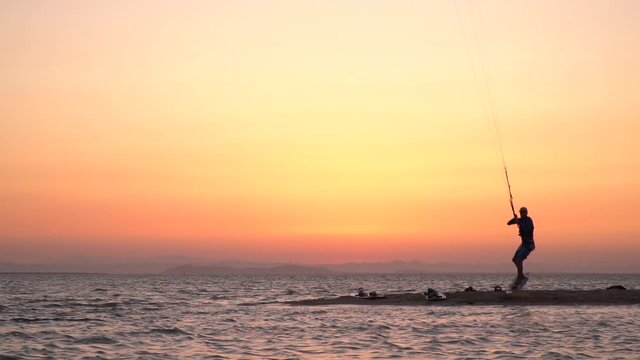 Kite surfer is jumping from the beach on water, fails and falls in it