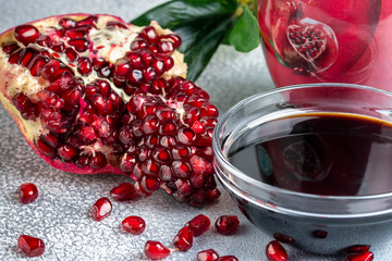 Narsharab. Saucer with pomegranate sauce with fresh ripe pomegranate fruits with leaves on a light...