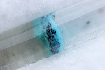 Layer of insoluble blue substance of copper silicate in test tube, in the snow.