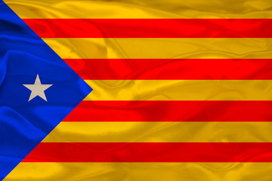 beautiful photo of a colored national flag of the modern state of Catalonia on textured fabric, concept of tourism, emigration, economy and politics, close up