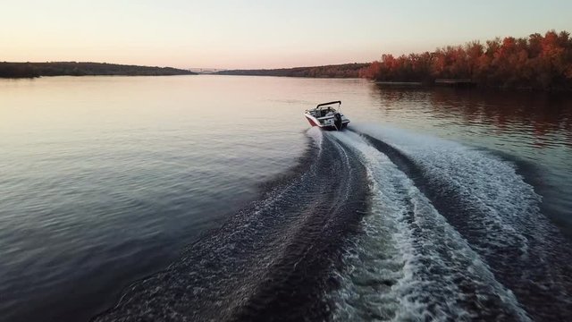  motor boat floating on the river at sunset