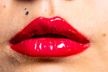 Knallrote volle Frauenlippen mit Glanzeffekt und glitzer