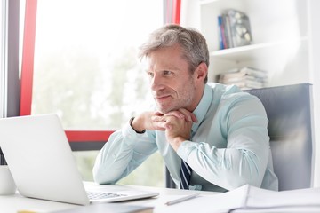 Mature businessman busy working on his desk in office