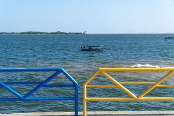 Wooden motor boat sailing on Tapajos river on sunny summer day in amazon with colorful sidewalk...