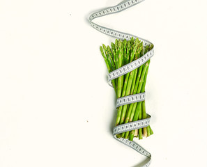 creative layout asparagus with measuring tape concept diet, healthy lifestyle, diet, vegetarian, top view, flat lay