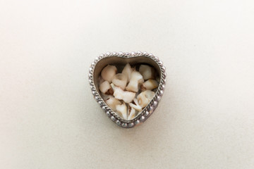 Collection of baby and childrens milk teeth in heart shaped container