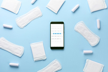 Tampons, feminine sanitary pads and gadget on blue background. Hygienic care on critical days. menstrual cycle. Caring for women's health. Monthly protection. Flat lay, top view, copy space