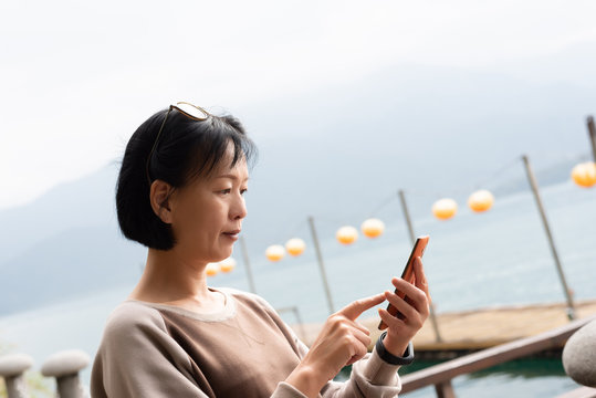 Mature Asian Woman Using Mobile Phone