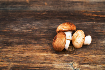 Pile of delicious champignon mushrooms on wooden background