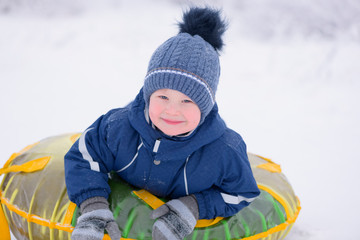 Fototapeta na wymiar The portrait of the happy cute toddler, 3 years old, is outdoors in winter.