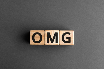 OMG - acronym from wooden blocks with letters, OMG abbreviation Oh My God concept, gray background