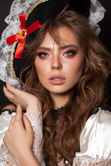 Young model with professional makeup, perfect skin, long wavy brown hair in a pirate costume....