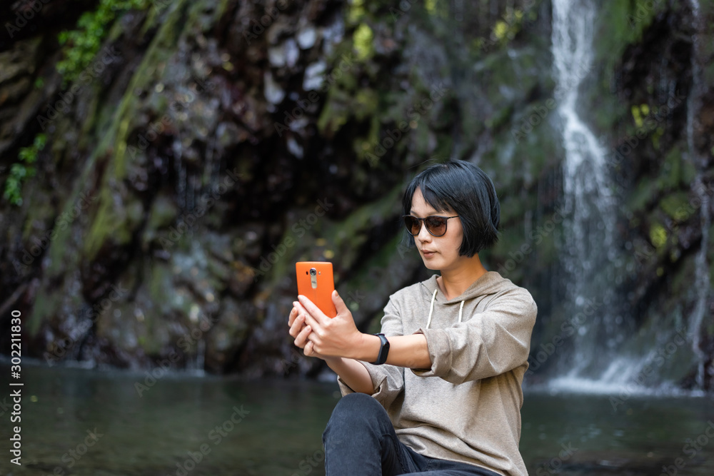 Wall mural woman selfie near the waterfall