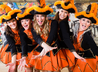 Funkenmariechen im Karneval ziehen den Dreispitz-Hut und lächeln 