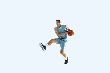 Fototapeta na wymiar High flight. Young caucasian basketball player of team in action, motion in jump isolated on white background. Concept of sport, movement, energy and dynamic, healthy lifestyle. Training, practicing.