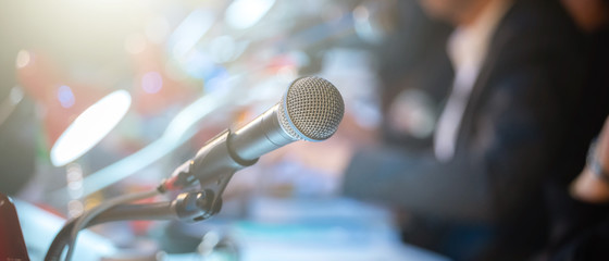 Business people talking on seminar panel with microphone