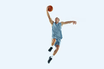 High flight. Young caucasian basketball player of team in action, motion in jump isolated on white...