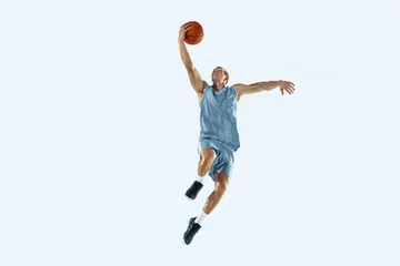 Poster High flight. Young caucasian basketball player of team in action, motion in jump isolated on white background. Concept of sport, movement, energy and dynamic, healthy lifestyle. Training, practicing. © master1305